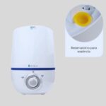 Umidificador de ar ultrassônico Umi Pop Dellamed, na cor branca, em fundo neutro. A imagem mostra o umidificador ligado, com a névoa visível saindo pela parte superior.